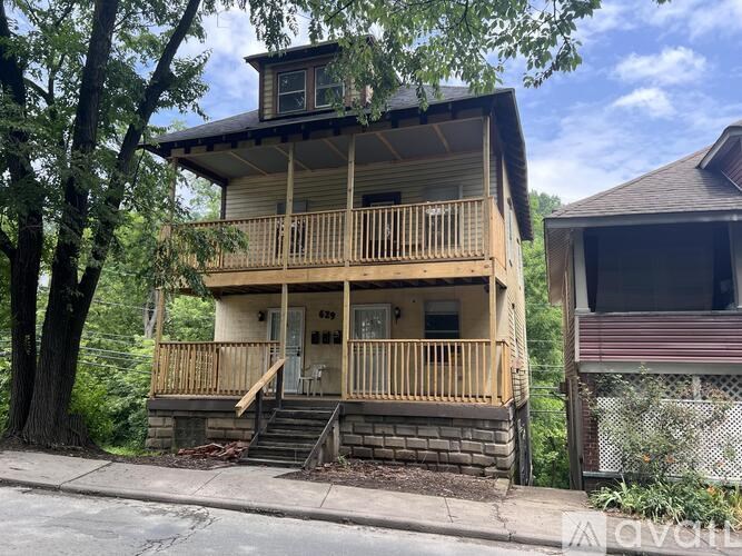 A two-story house with a balcony and a small porch.