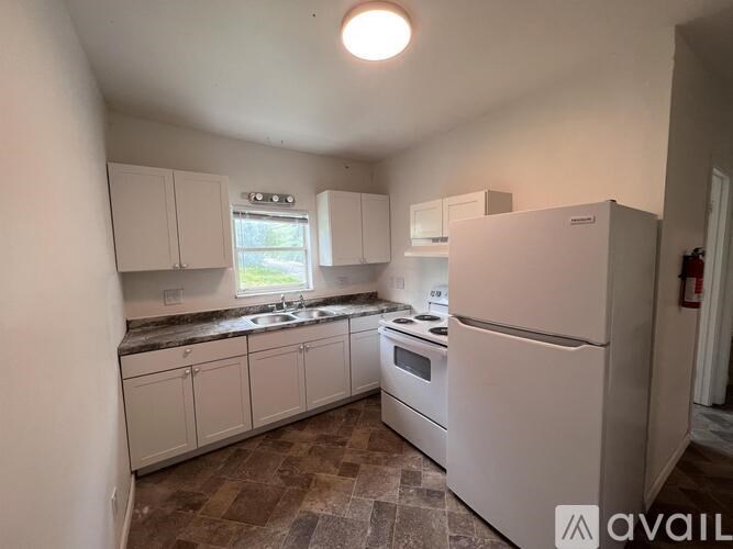 A kitchen with white appliances and cabinets.