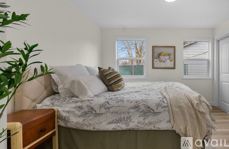 A bedroom with a large bed and a painting on the wall.