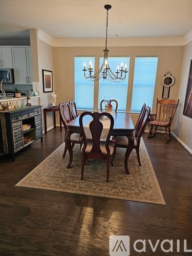 A dining room with a large table and chairs.
