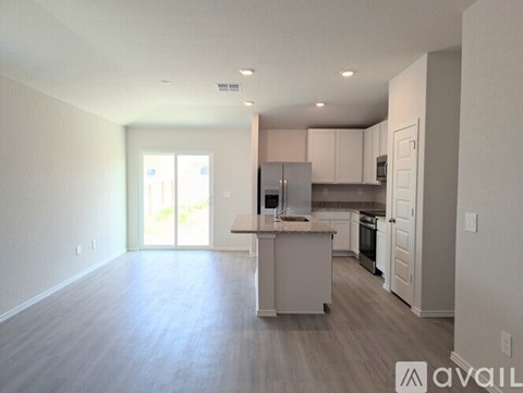 A kitchen with white cabinets and a wooden floor.