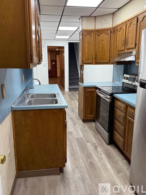 A kitchen with wooden cabinets and a blue backsplash.