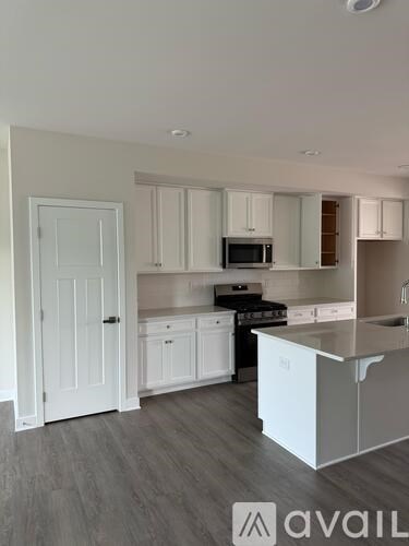 A kitchen with white cabinets and a stainless steel island.