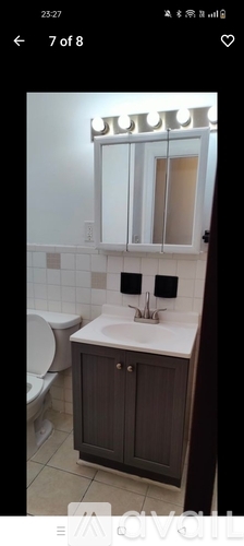 A bathroom with a toilet, sink, and mirror.