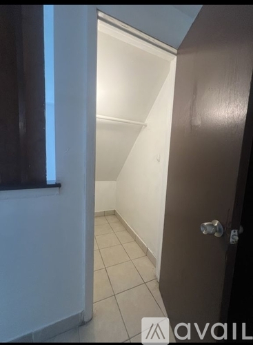 A hallway with a door on the right and a window on the left.
