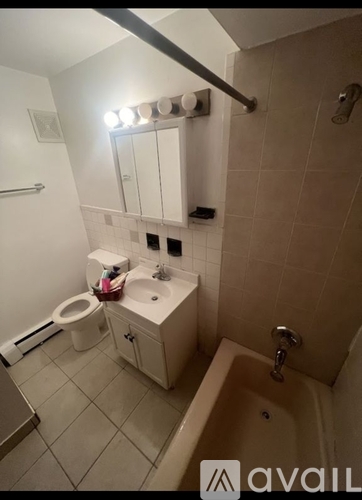 A bathroom with a toilet, sink, mirror, and bathtub.
