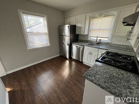 A kitchen with a black stove top oven and a black fridge.
