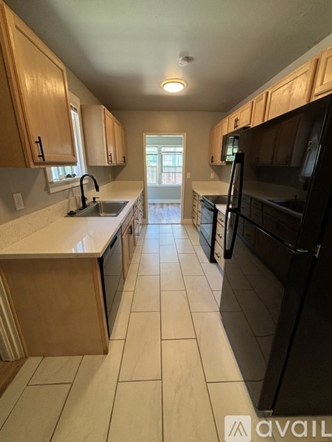 A kitchen with wooden cabinets and black appliances.