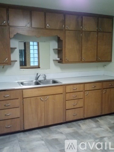 A kitchen with wooden cabinets and a sink.