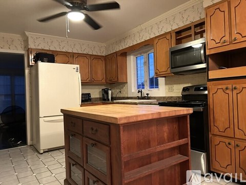 A kitchen with wooden cabinets and a white refrigerator.