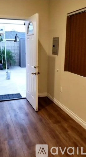 A hallway with a door leading to a balcony.