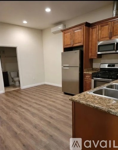 A kitchen with a refrigerator, stove, and microwave.