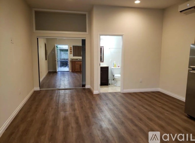 A room with wooden flooring and a large mirror on the wall.
