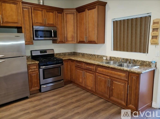 A kitchen with wooden cabinets and granite countertops.