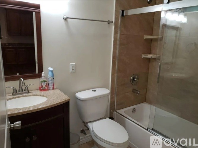 A bathroom with a toilet, sink, and shower.