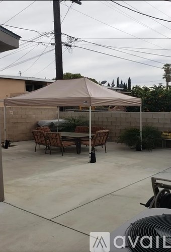 A patio with a table and chairs under a canopy.