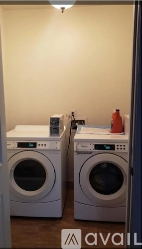 Two front load washing machines are in a laundry room.