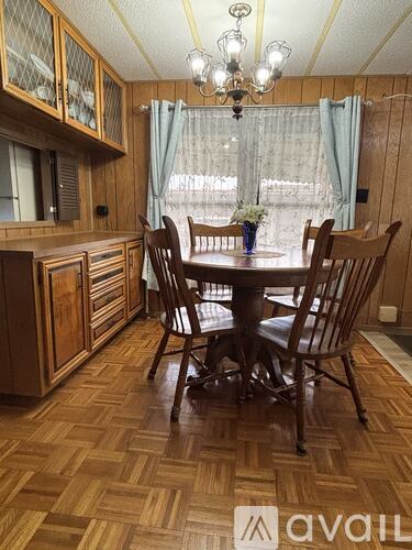 A wooden dining room with a table and chairs.