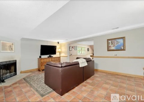 A living room with a brown couch and a fireplace.
