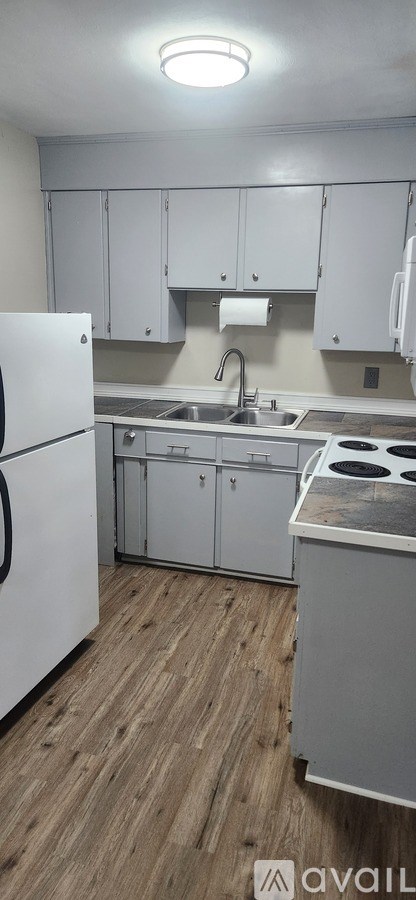 A kitchen with white appliances and cabinets.