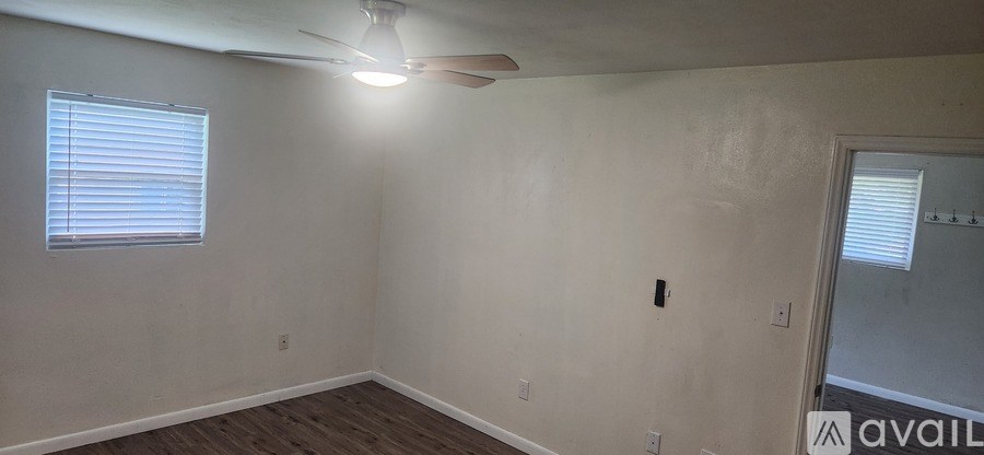 A room with a ceiling fan and a window with blinds.