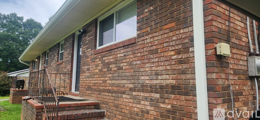 A brick house with a white roof and a window.