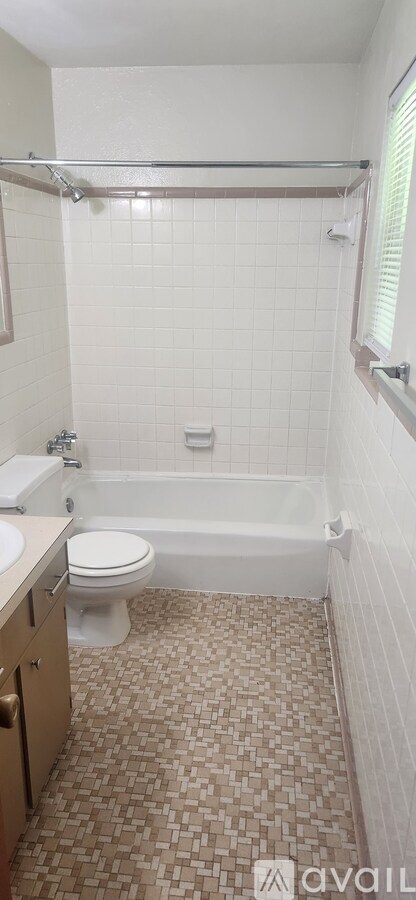 A bathroom with a toilet, sink, and bathtub.