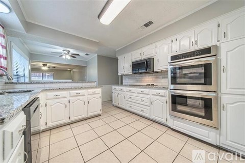 A kitchen with white cabinets and appliances.