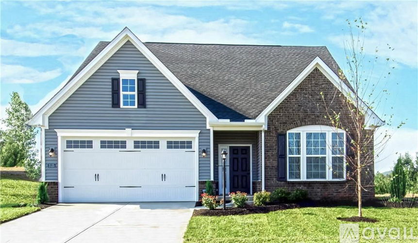 A grey house with a black garage door.
