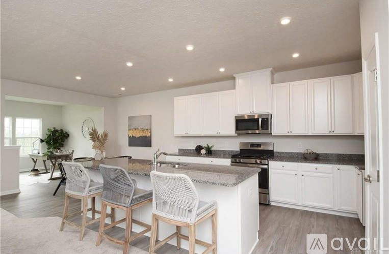 A kitchen with white cabinets and a marble countertop.