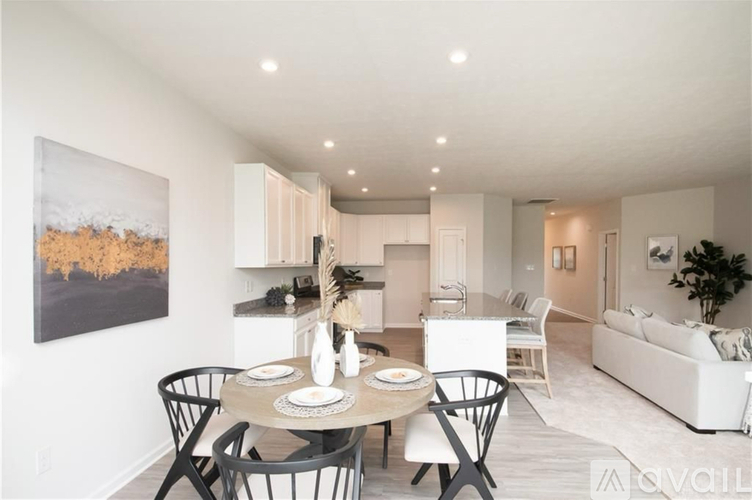 A modern dining room with a round table set for four.