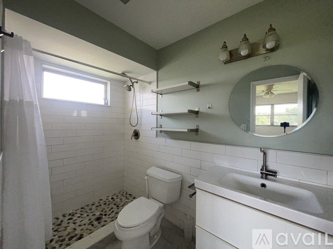 A bathroom with a toilet, sink, and shower.