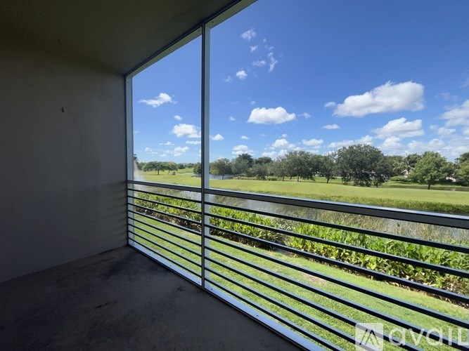 A room with a large window overlooking a green landscape.