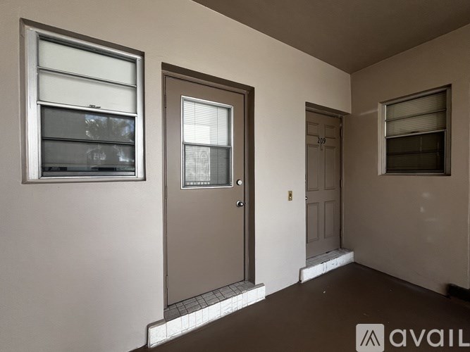 A room with a brown door and a window with blinds.