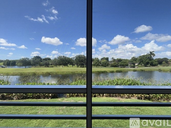 A view of a lake through a window with a metal frame.