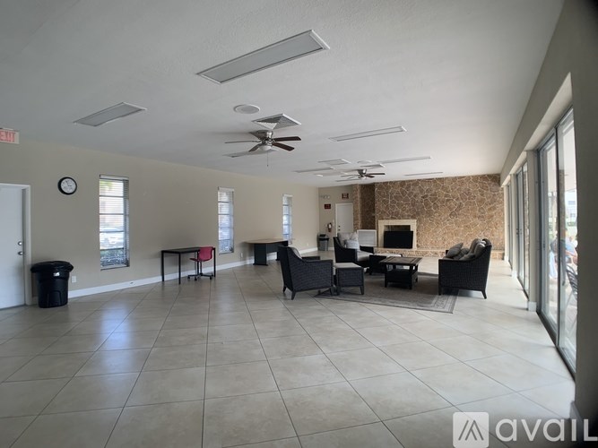 A spacious living room with a brick wall and a fireplace.