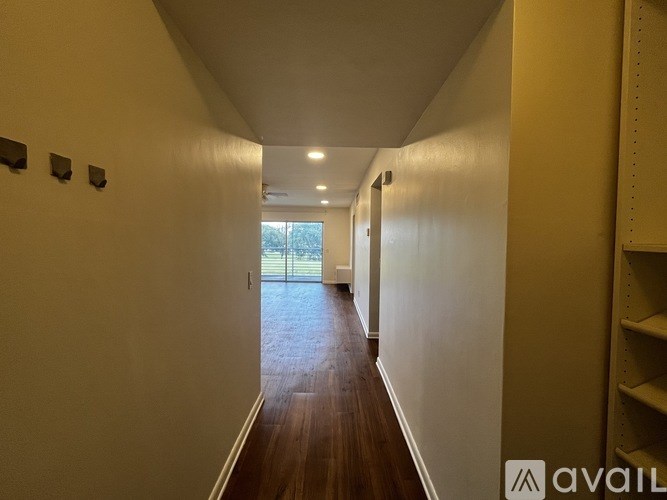 A long hallway with wooden floors and white walls.