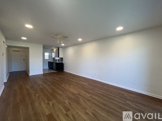 A room with wooden flooring and a ceiling fan.