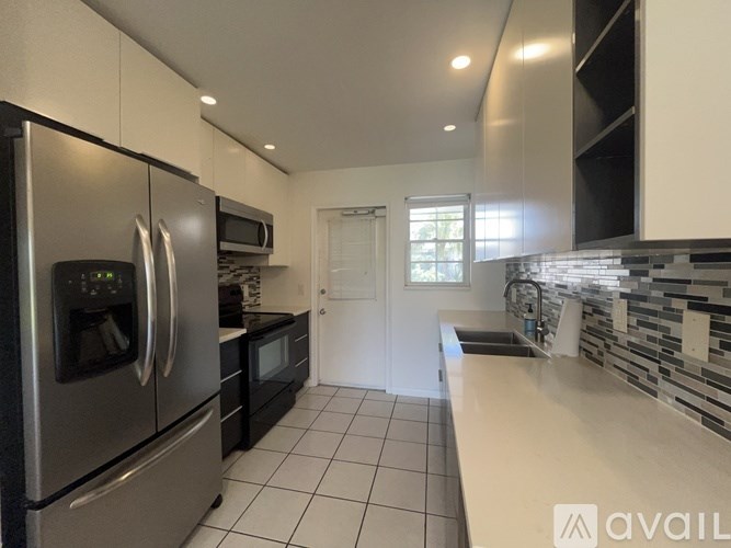 A kitchen with a refrigerator, microwave, and oven.