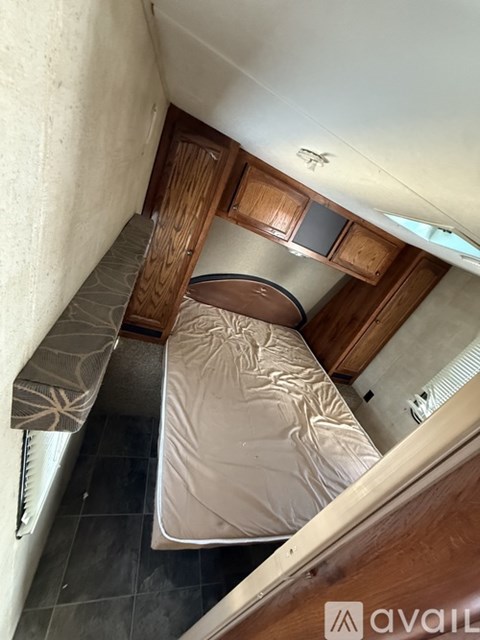 A small bedroom with a bed and a bench seat.