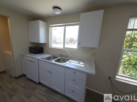 A kitchen with white cabinets and a marble countertop.