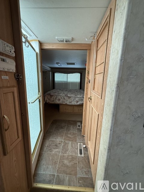 A small bedroom with a bed and a wooden door.