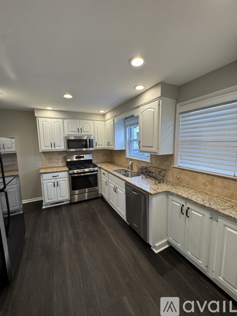 A kitchen with white cabinets and a granite countertop.
