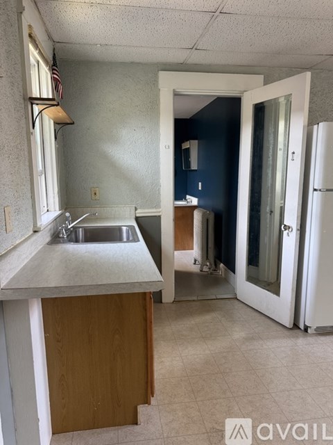 A kitchen with a sink and a refrigerator.