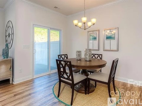 A dining room with a round table and chairs.