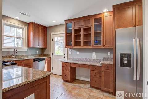 A kitchen with wooden cabinets and a granite countertop.