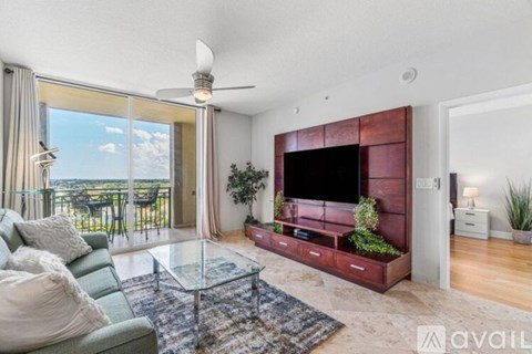 A living room with a green couch and a glass coffee table.