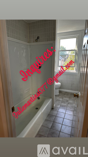 A bathroom with a tub and a toilet.