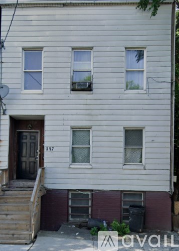 A white house with a brown door and windows.
