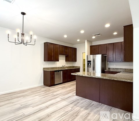 A kitchen with brown cabinets and a marble countertop.